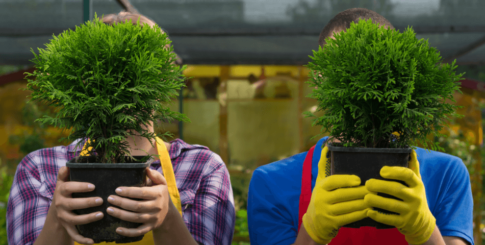 Two people hold plants in front of their faces